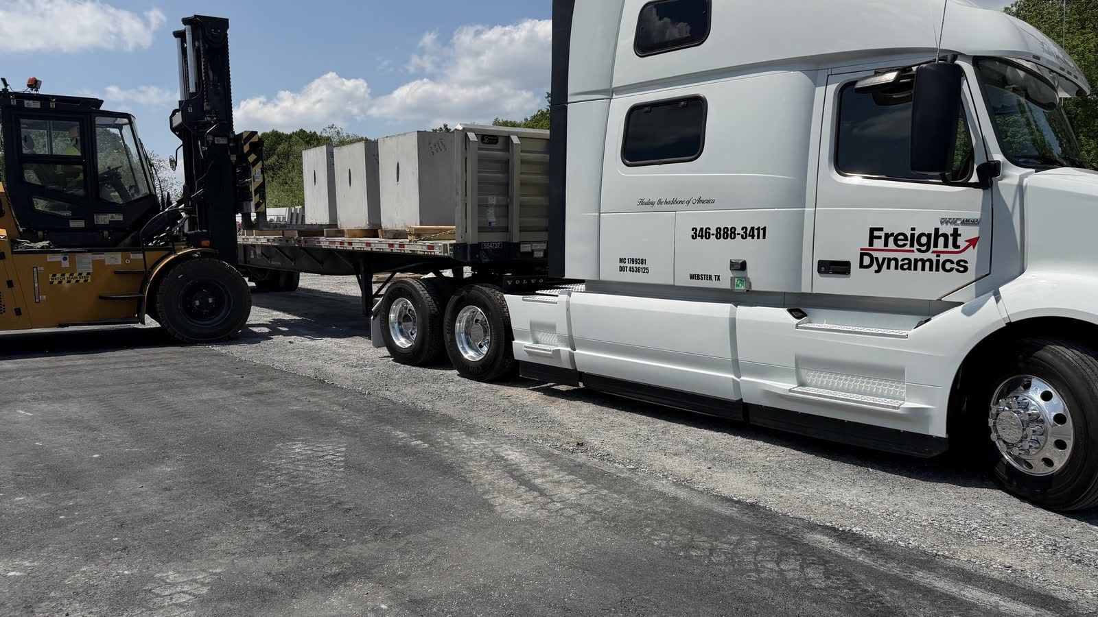 Forklift loading a Freight Dynamics flatbed
